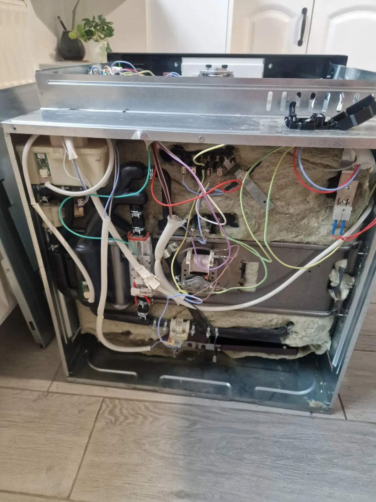 Kuchnia elektryczna ze zdjętą tylną obudową — okablowanie i grzałki piekarnika